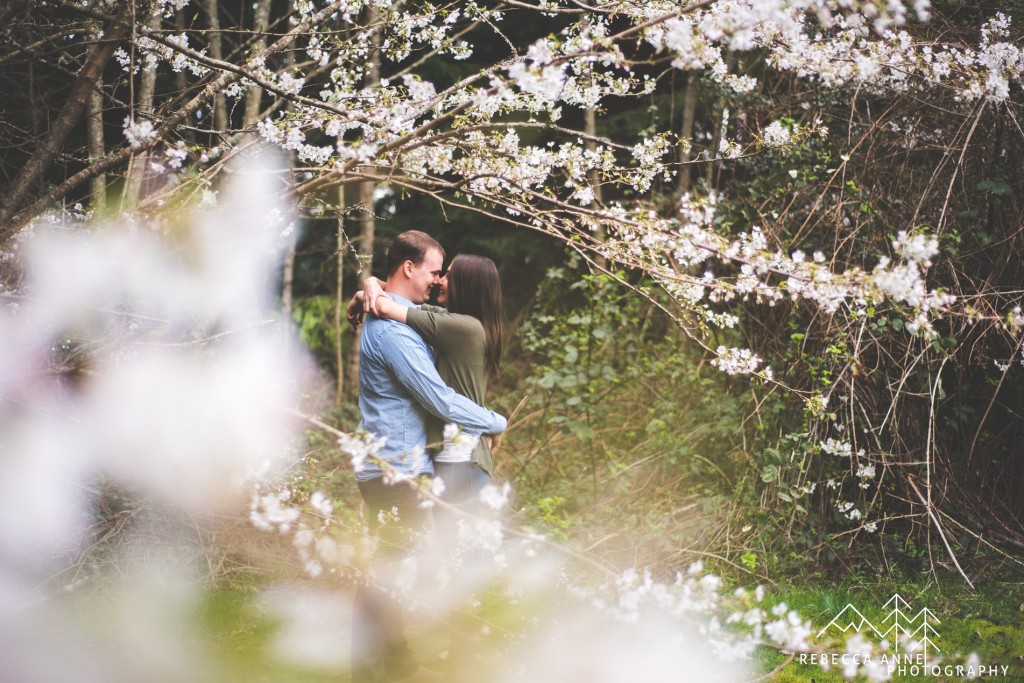 Almost kissing cherry blossoms engagement photo pose idea